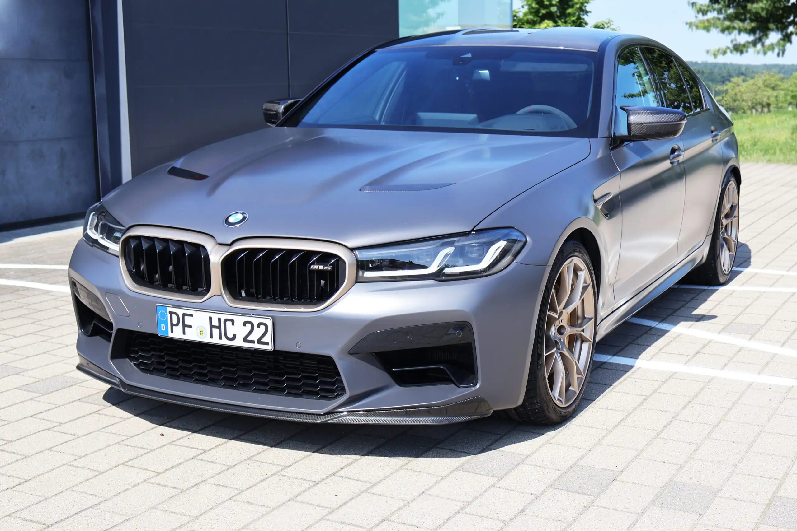 Matte graue BMW mit goldenen Felgen nach Fahrzeugumbau bei Hiller CarTech nahe Pforzheim